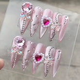 VIBEFICANT GLAZE pink cat eye long stiletto press-on nails with rhinestones and bows.